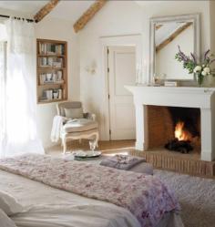 Country style bedroom with open fire and French doors to patio