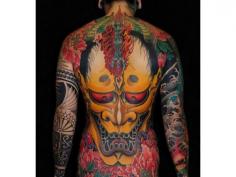 Japanese tattoo on man's back with gold Oni mask